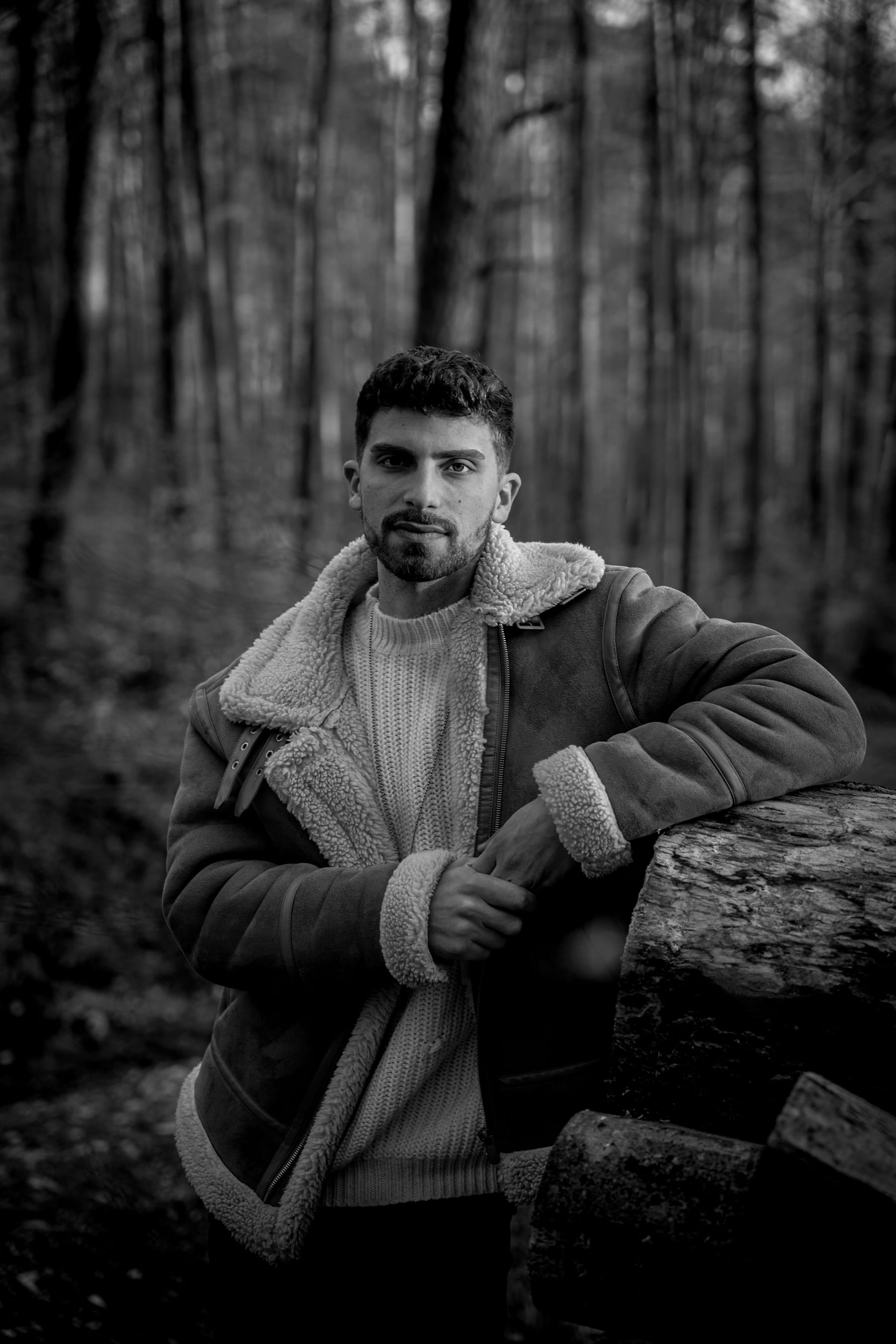 Luis Grau im Wald, an einen Baumstamm gelehnt, Blick in die Kamera
